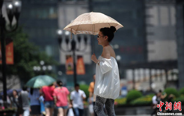 重庆市民图片:重庆气温近40℃市民面盆扣头挡烈日