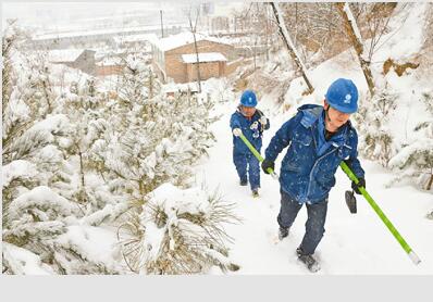 延安张思德电力服务队踩着大雪为村民恢复供电